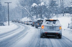 Danger Winter Driving Conditions Cars moving slowly on snowy street