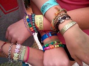 Friends showing off their wristbands for events