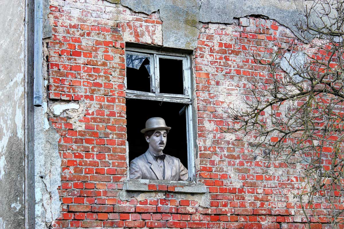 Charlie Chaplin looking out of a window...lonely from close event businesses